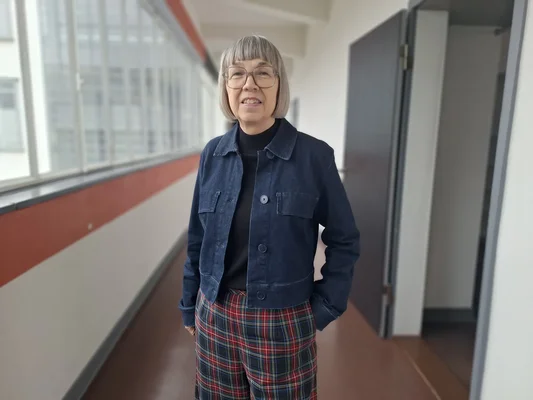 Portrait d'une personne dans un couloir du Bauhaus, évoquant l'héritage vivant du mouvement.
