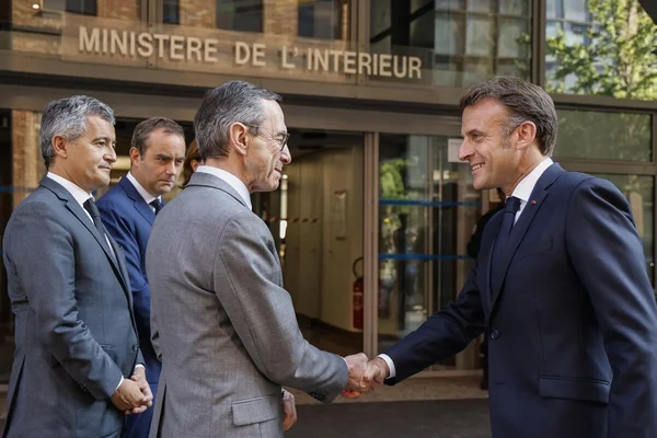 Emmanuel Macron serrant la main d'un représentant à l'entrée du ministère de l'Intérieur.