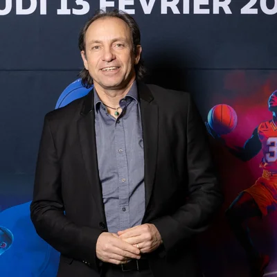 Philippe Candeloro, nouveau président de la Fédération française des sports de glace, devant un fond promotionnel.