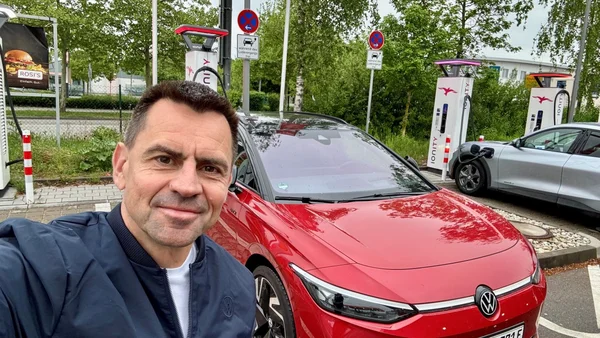 Martin Sander posant à côté d'une Volkswagen ID.3 électrique à une borne de recharge.