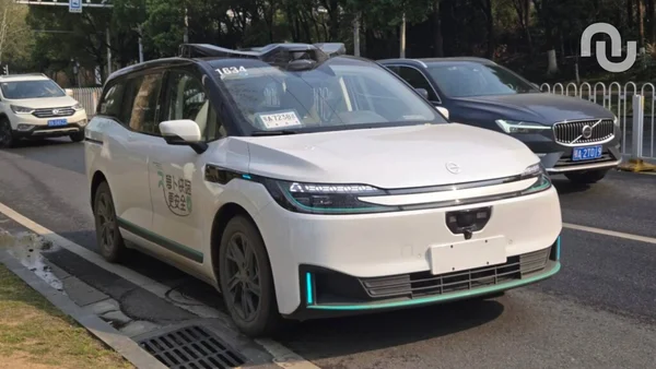 Un robotaxi AutoX basé sur le Roewe iMAX8, équipé de capteurs, en situation urbaine.