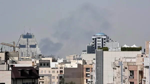 Panache de fumée au-dessus d'une ville iranienne après des frappes américaines et israéliennes.