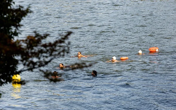 Nageurs profitant de la baignade dans la Seine, avec bouées et équipements de sécurité.