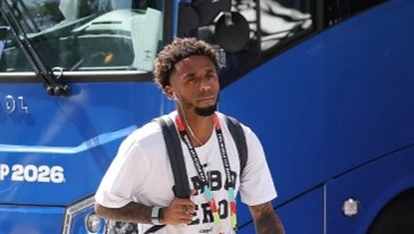 Un homme non identifié marche devant un bus de la Coupe du monde 2026.