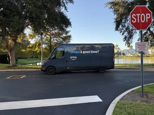 Un fourgon de livraison électrique Amazon Prime (Rivian) circule dans un quartier résidentiel à Orlando, Floride.