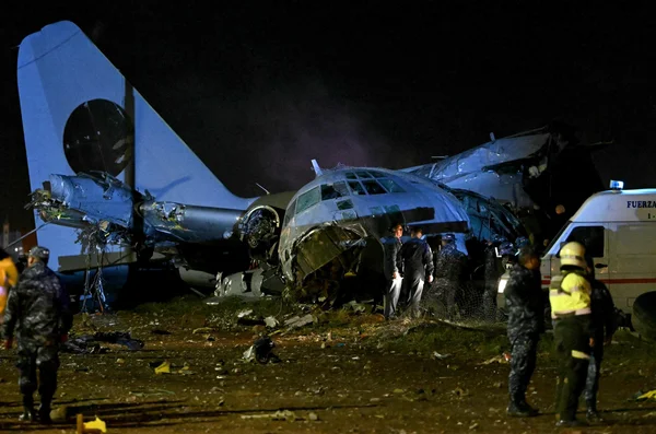 Épave d'un avion accidenté examinée par les secours et la police de nuit.