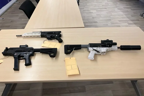 Armes modifiées ou répliques saisies, avec étiquettes de preuve.
