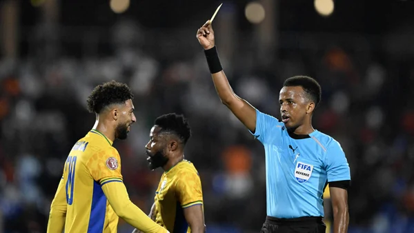 Omar Artan brandissant un carton jaune lors d'un match.
