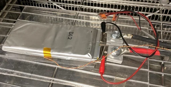 Cellule DL2 de Donut Lab sur un banc de test, avec pinces crocodile.