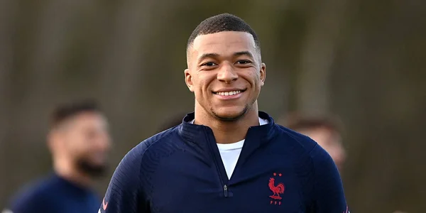 Kylian Mbappé posant avec la main sur l'écusson lors d'un entraînement.