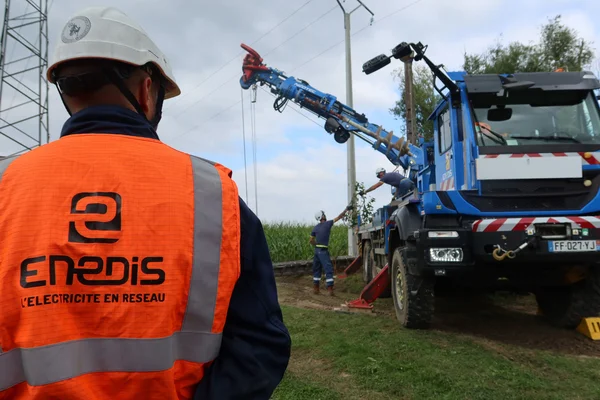 Intervention d'Enedis sur le réseau électrique pour renforcer la résistance face aux conditions climatiques extrêmes.