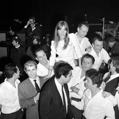 Françoise Hardy portée en triomphe lors d'un événement, photographie en noir et blanc.