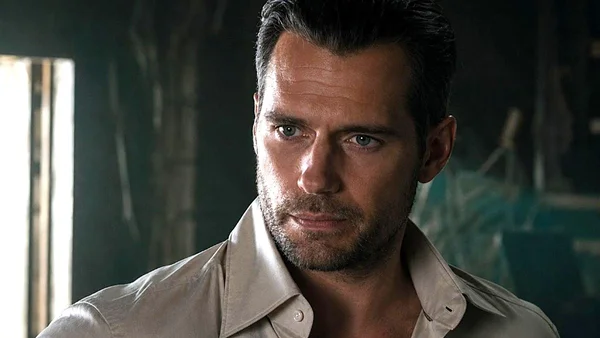 Henry Cavill dans un portrait rapproché, regard intense dans une lumière tamisée.