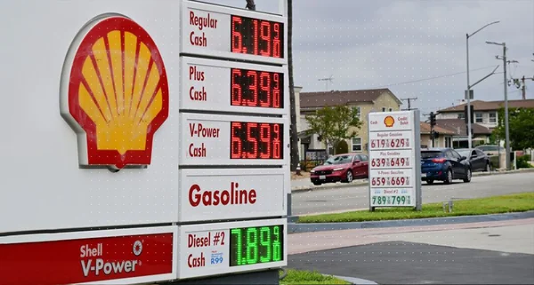 Panneau de prix d'une station-service Shell dans un quartier résidentiel.