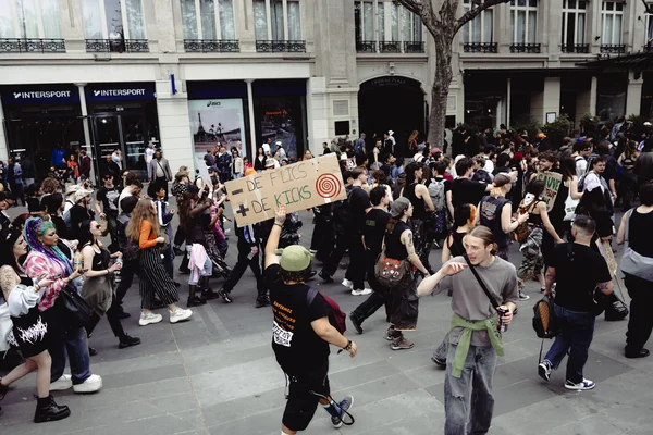 Manifestation contre la répression des free parties à Paris : des milliers de personnes défilent, une pancarte revendicative 'DE FLICS + DE KICKS' brandie.