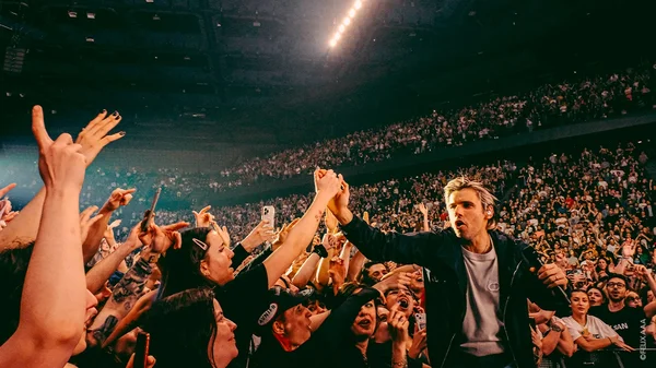 Orelsan en concert lors de sa tournée 2026, interagissant avec le public.