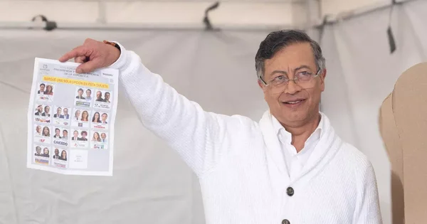 Un électeur colombien tient un bulletin de vote présidentiel dans un isoloir.