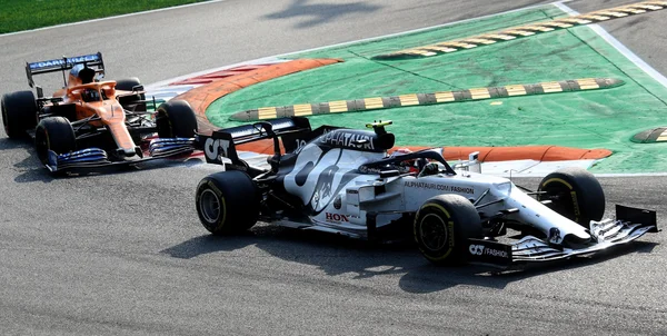 Une AlphaTauri et une McLaren en pleine course sur un circuit.