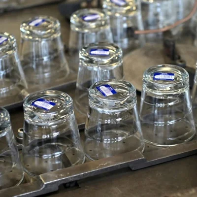 Chaîne de fabrication Duralex : des verres en cours de traitement sur un tapis roulant.
