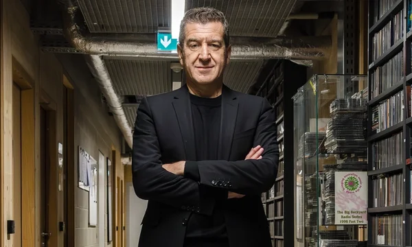 Matthieu Pigasse dans un couloir, bras croisés, portant un blazer noir sur une chemise noire.
