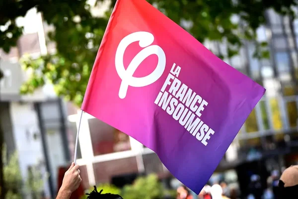 Drapeau de La France Insoumise agité lors d'un rassemblement.