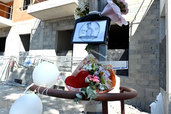 Hommage floral et portrait de Louis déposés près du chantier où il a été tué.