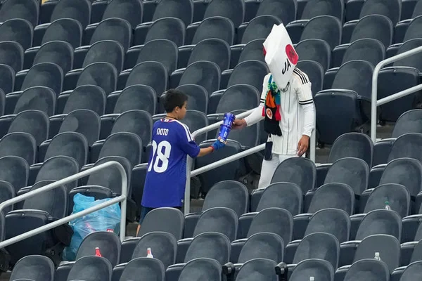 Un jeune supporter japonais participe au nettoyage des tribunes lors de la Coupe du monde.