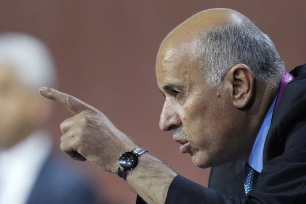 Jibril Rajoub s'adressant à la presse, le doigt levé, dans un cadre professionnel.