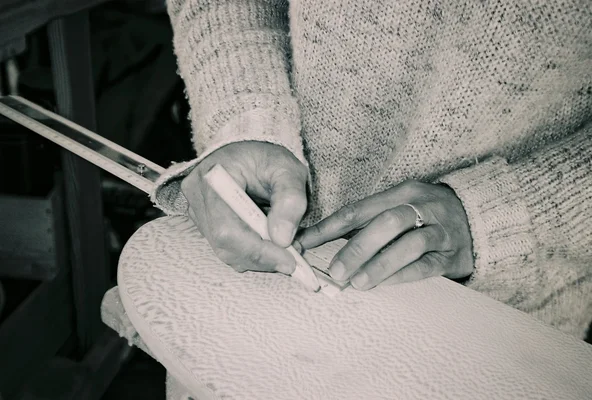 Détail des mains d'Elisa Routa en train de dessiner, illustrant son processus créatif.