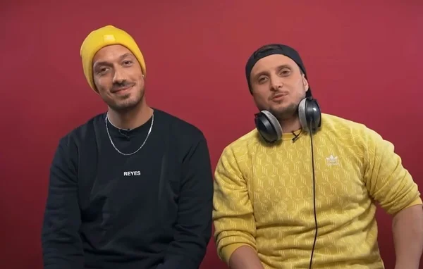 McFly et Carlito posant devant un fond rouge.