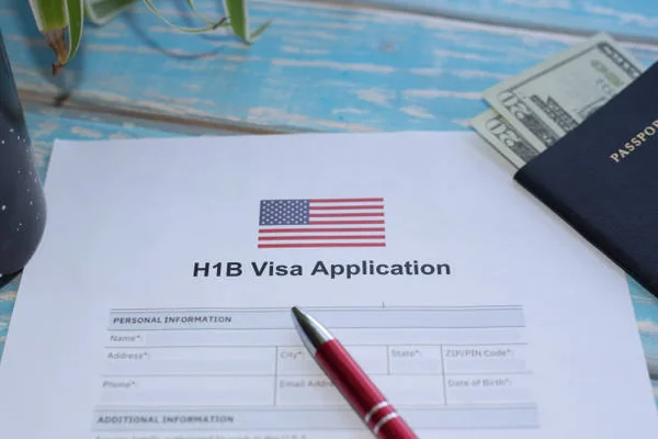 Formulaire de demande de visa H-1B avec passeport, stylo et billets de dollars.