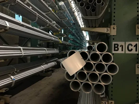 Stock de tubes en aluminium dans un entrepôt industriel, illustrant les tensions d’approvisionnement.