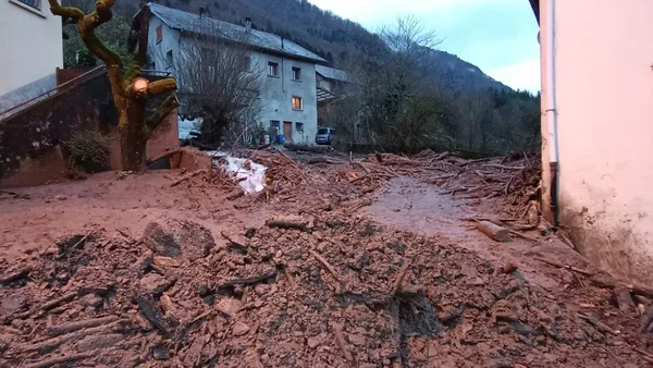 Une coulée de boue traverse un village en Savoie, laissant des débris et de la boue entre les habitations.
