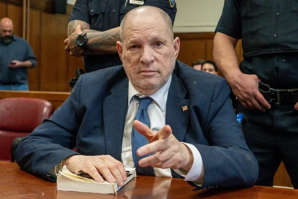 Harvey Weinstein lors de son procès à New York, entouré d'agents de sécurité.