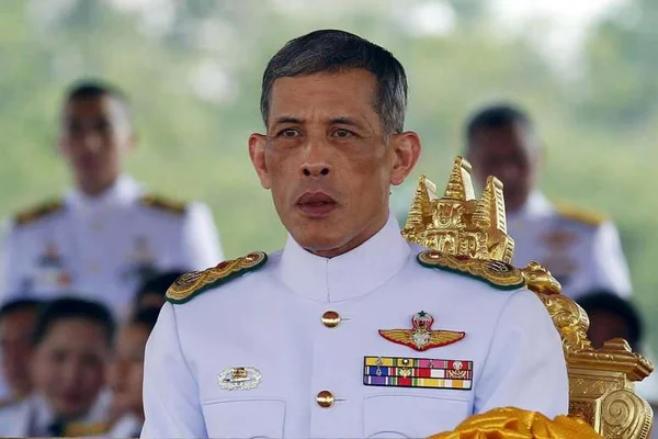 Le roi Maha Vajiralongkorn en uniforme militaire, assis sur un trône doré