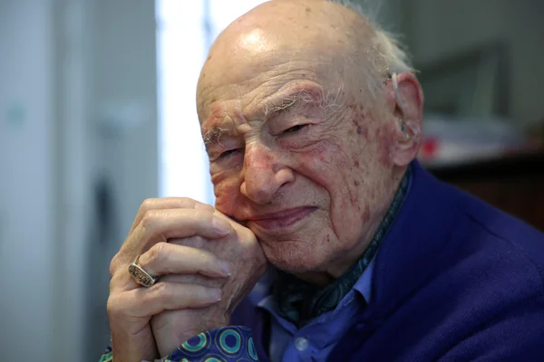Edgar Morin en pull bleu, souriant.