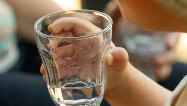 Enfant buvant un verre d'eau, rappelant l'importance de l'hydratation en cas d'infection intestinale.