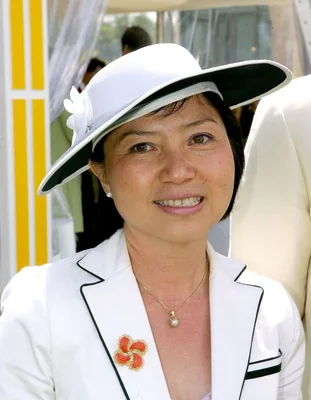 Anh Dao Traxel, élégante en blanc et noir, avec une broche fleur rouge.