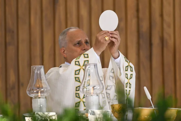 Un prêtre élève l'hostie lors de la messe célébrée par le pape Léon XIV à Madrid.
