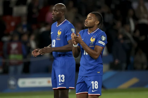 Jean-Philippe Mateta (n°13) avec un coéquipier sous le maillot bleu de l'équipe de France, saluant le public.
