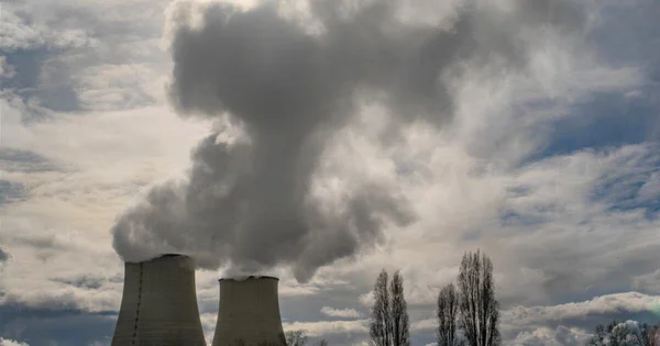 Tours de refroidissement d'une centrale nucléaire émettant de la vapeur par forte chaleur.