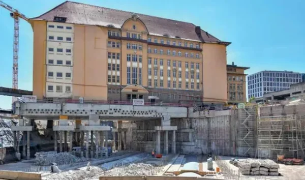 Le bâtiment historique de la gare de Stuttgart surélevé sur une structure en béton pendant les travaux.