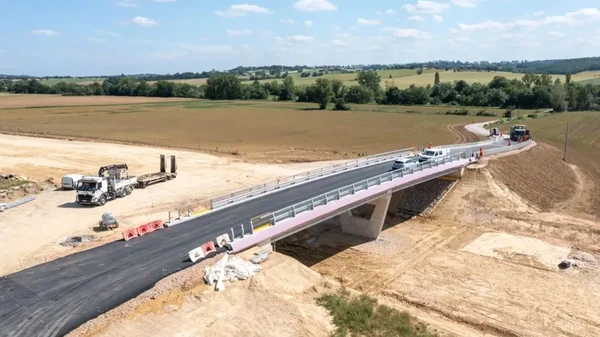 Vue aérienne du chantier de l'A69 montrant un pont en béton neuf et des engins de construction.