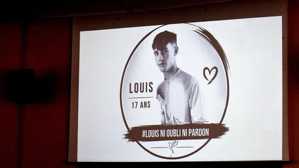 Hommage à Louis projeté sur un écran lors d'une prise de parole.