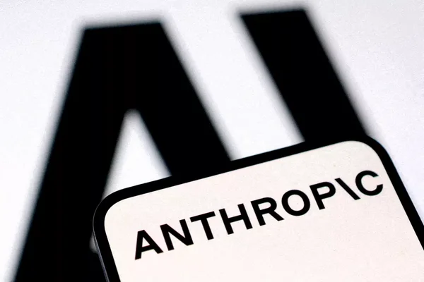 Le logo d'Anthropic sur un smartphone, avec le symbole de l'intelligence artificielle en arrière-plan.