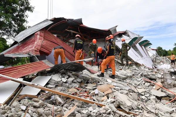 Des secouristes recherchent des survivants dans les ruines d'un bâtiment effondré lors du séisme aux Philippines.