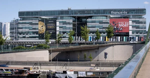 Le siège de France Télévisions à Paris, avec des banderoles promotionnelles sur la façade vitrée.
