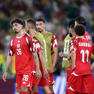 Joueurs de football en tenue rouge et blanche sur le terrain.
