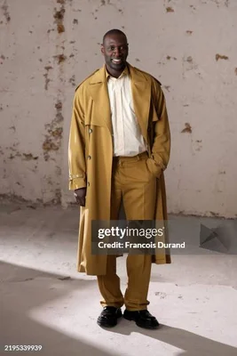Omar Sy en trench-coat jaune moutarde, photo Getty Images (filigrane présent).