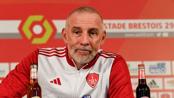 Éric Roy en conférence de presse, veste aux couleurs du club.